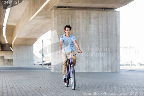 Image of young hipster man riding fixed gear bike