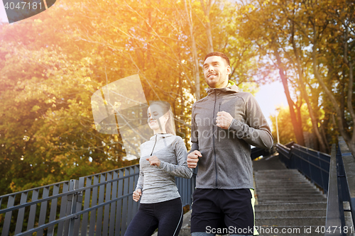 Image of happy couple running downstairs in city