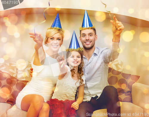 Image of smiling family in blue hats with cake