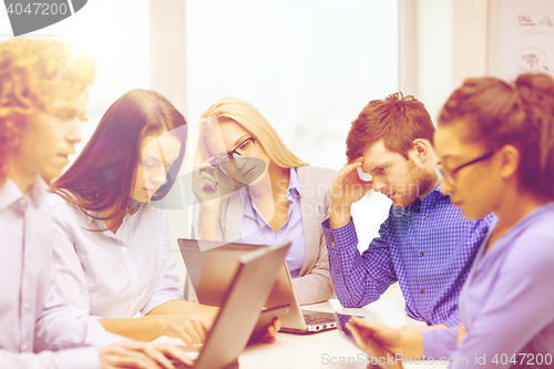 Image of depressed team with laptop and table pc computers