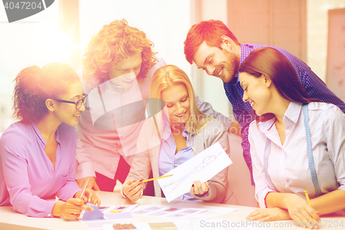 Image of smiling creative team looking at sketch