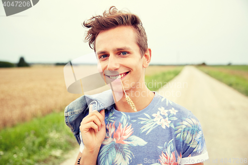 Image of smiling young hippie man on country road