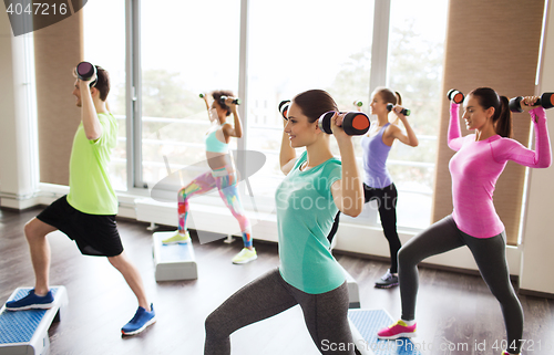 Image of group of people with dumbbells and steppers