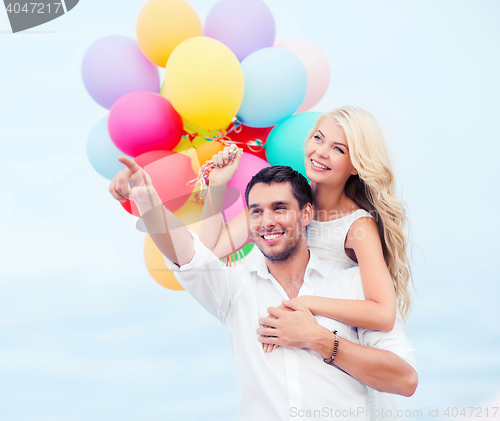 Image of couple with colorful balloons at sea side
