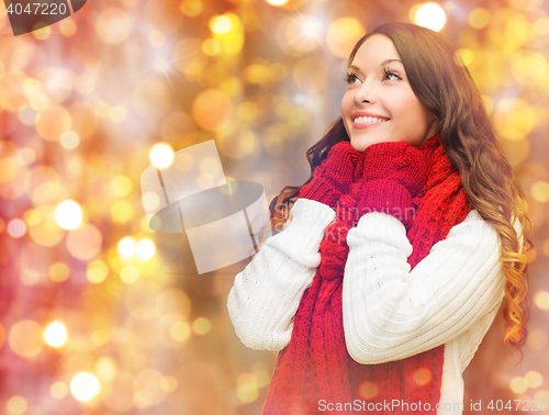 Image of happy woman in scarf and mittens over lights