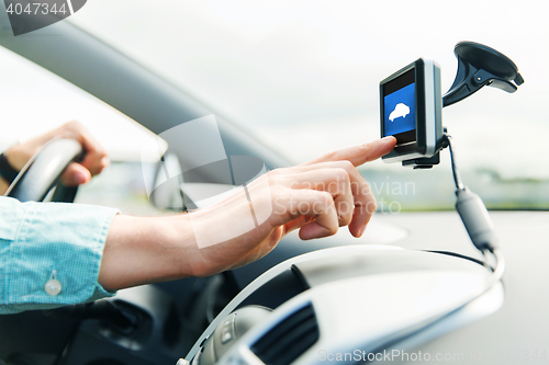 Image of close up of man with gadget on screen driving car