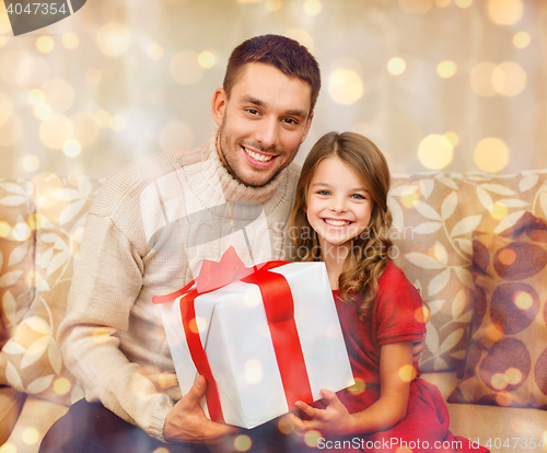 Image of smiling father and daughter holding gift box