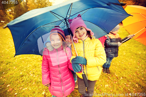 Image of happy children with umbrella in autumn park