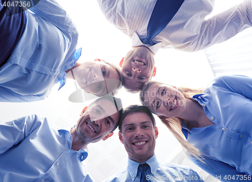 Image of smiling group of businesspeople standing in circle