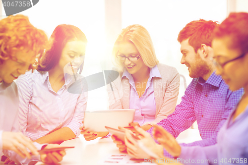 Image of smiling team with table pc and papers working