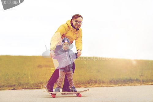 Image of happy father and little son on skateboard