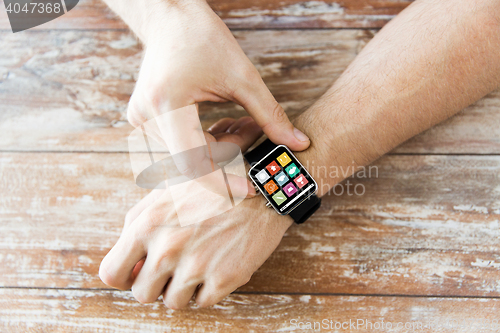 Image of close up of hands setting smart watch with icons
