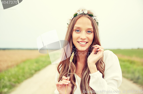 Image of smiling young hippie woman on cereal field