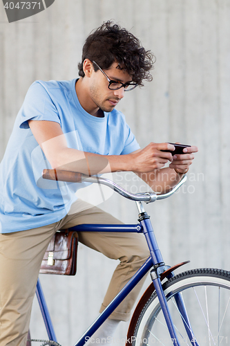 Image of man with smartphone and fixed gear bike on street