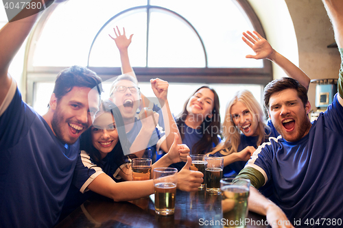 Image of football fans or friends with beer at sport bar