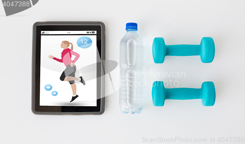 Image of close up of tablet pc, dumbbells and water bottle