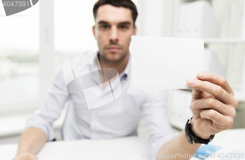 Image of close up of businessman with blank paper at office