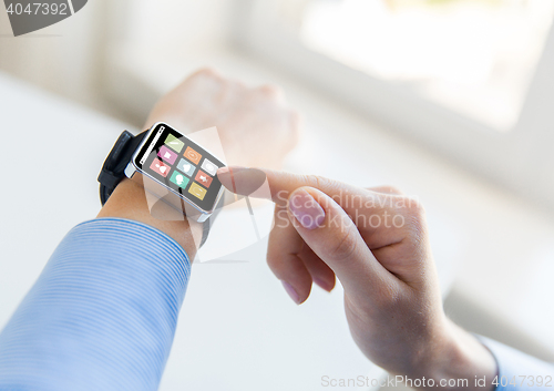 Image of close up of hands setting smart watch with icons