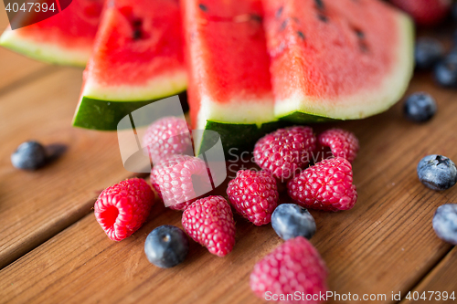 Image of close up of fruits and berries on wooden table