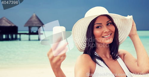 Image of young woman taking selfie with smartphone
