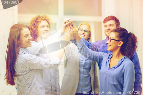 Image of creative team doing high five gesture in office