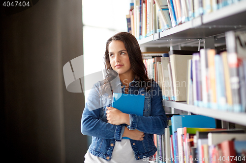 Image of high school student girl with book at library