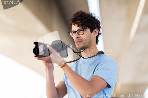 Image of photographer with digital camera shooting in city