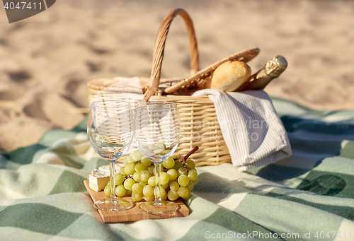 Image of picnic basket with wine glasses and food on beach