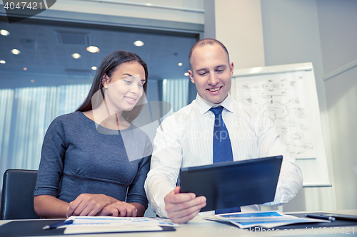 Image of smiling businesspeople with tablet pc in office