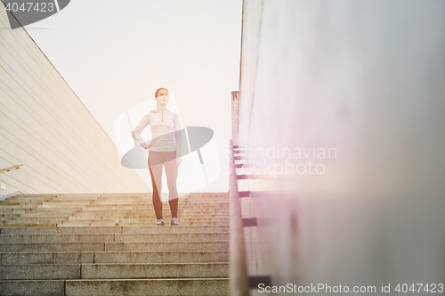 Image of sporty woman standing on in city stairs