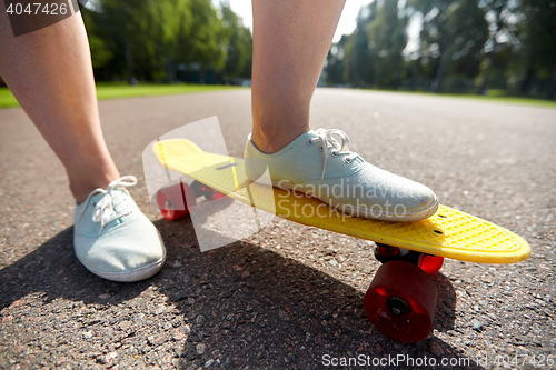 Image of close up of female feet riding short skateboard