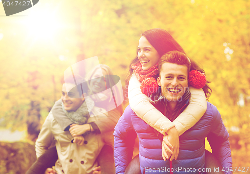 Image of smiling friends having fun in autumn park