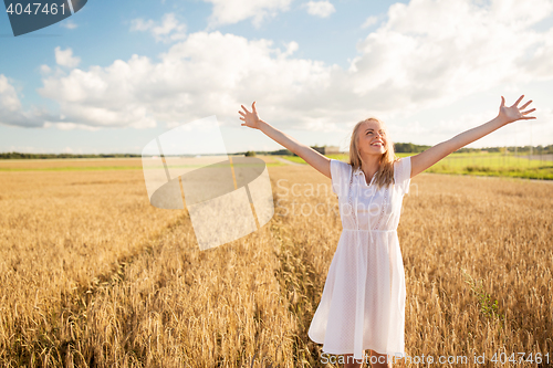 Image of smiling young woman in white dress on cereal field