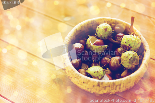 Image of close up of chestnuts in basket on wooden table
