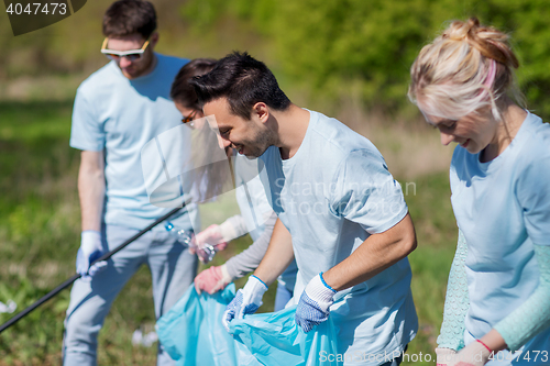 Image of volunteers with garbage bags cleaning park area