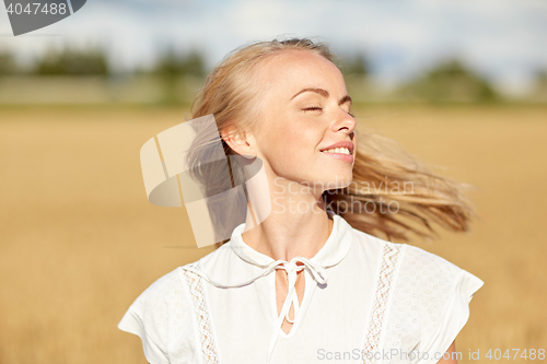 Image of smiling young woman in white on cereal field