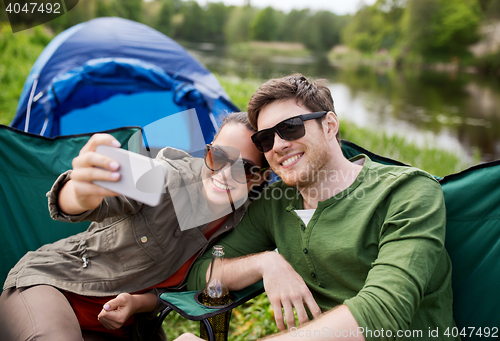 Image of couple of travelers taking selfie by smartphone