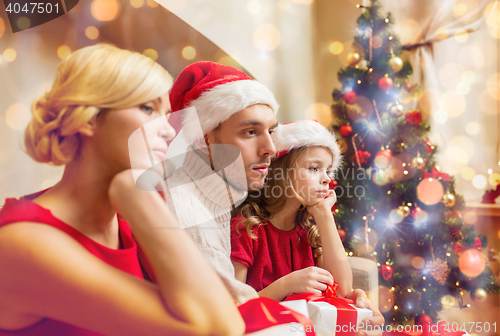 Image of depressed family at home with many gift boxes