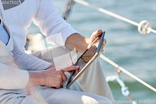 Image of senior couple with tablet pc on sail boat or yacht