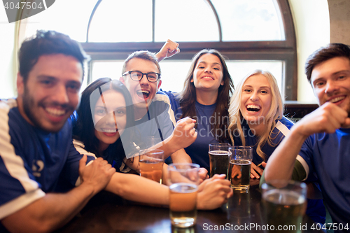 Image of football fans or friends with beer at sport bar