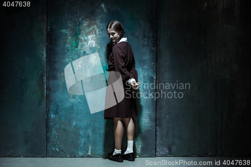 Image of Portrait of a young smiling girl in school uniform as killer woman