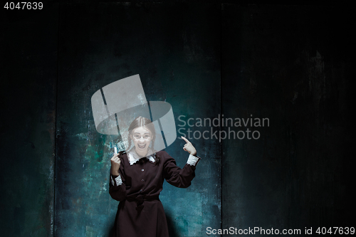 Image of Portrait of a young smiling girl in school uniform as killer woman