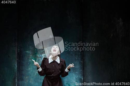 Image of Portrait of a young smiling girl in school uniform as killer woman