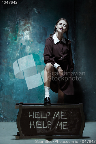 Image of Portrait of a young smiling girl in school uniform as killer woman