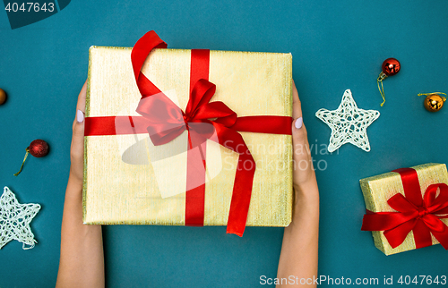 Image of Hands of woman and Christmas gift box.