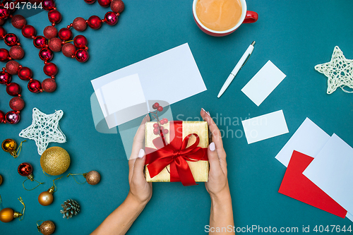 Image of Hands of woman and Christmas gift box.