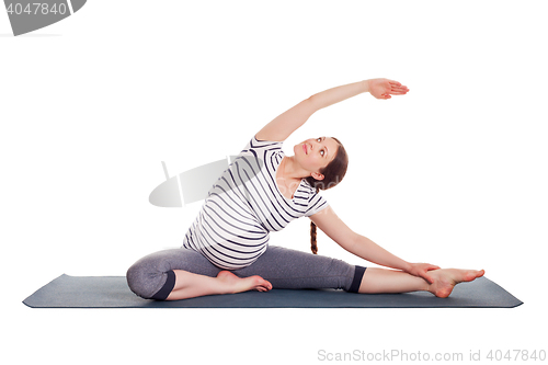 Image of Pregnant woman doing yoga asana Parivrtta janu sirsasana