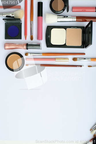 Image of makeup brush and cosmetics, on a white background