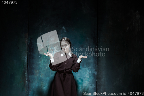 Image of Portrait of a young smiling girl in school uniform as killer woman