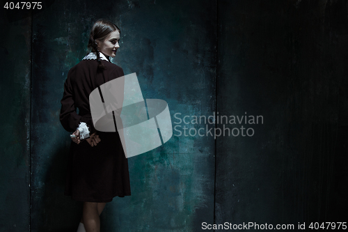 Image of Portrait of a young smiling girl in school uniform as killer woman